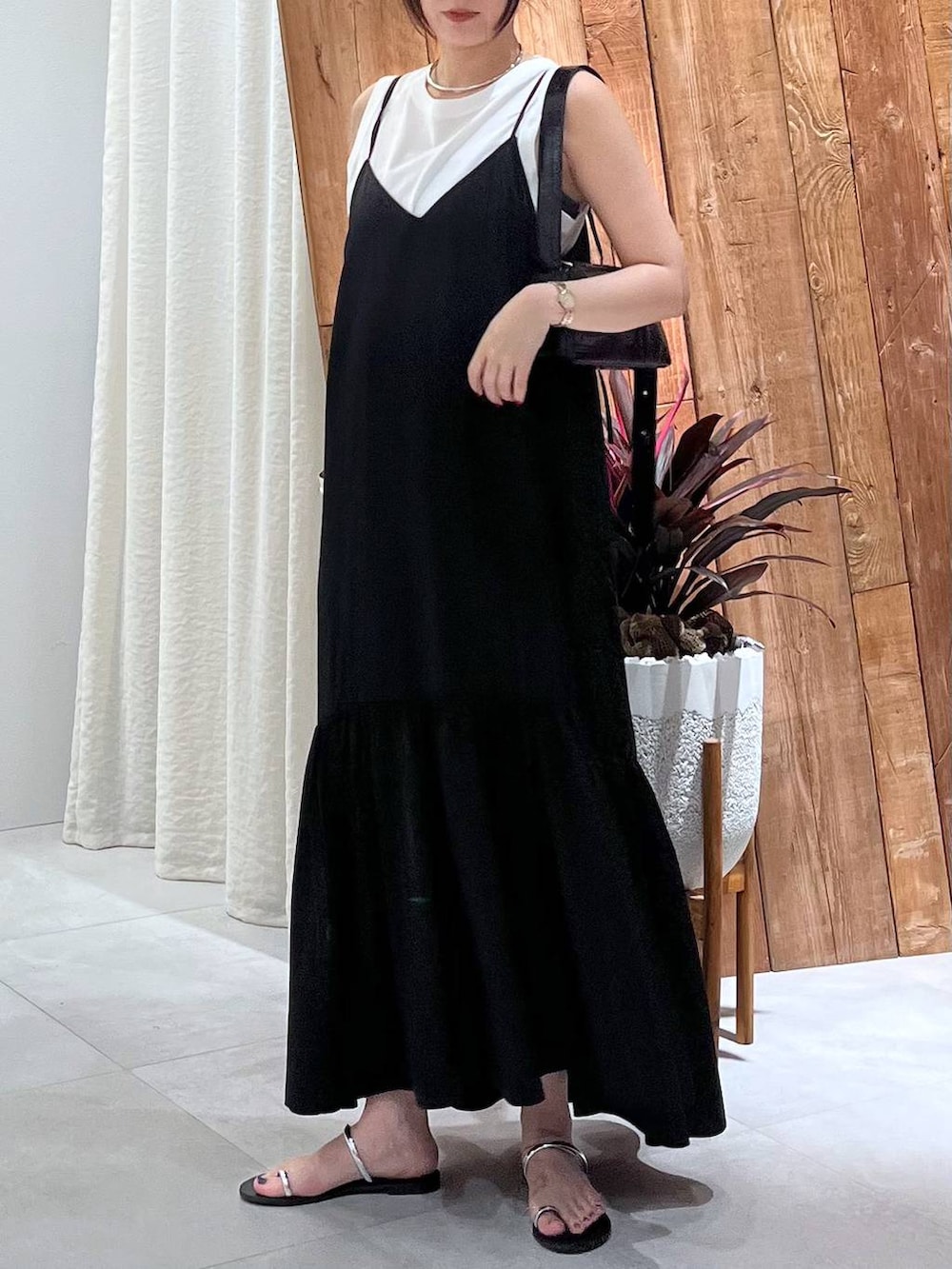 ブラック系のサンダル、ホワイト系のタンクトップ、グレー系のキャミソールを着用したレディースの夏コーディネートの4枚目の写真