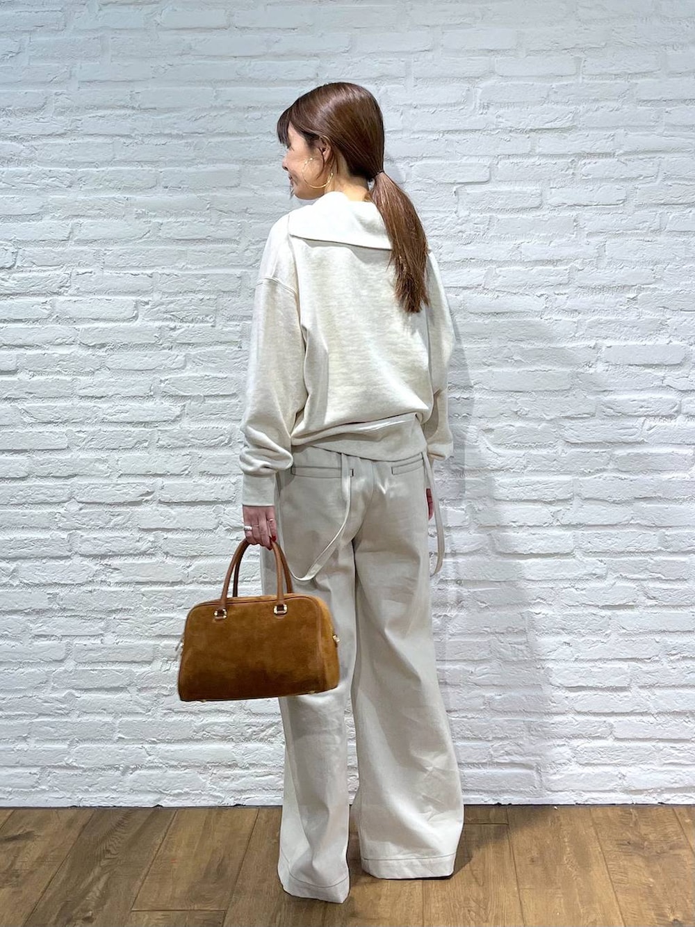 ホワイト系のスウェット、グレー系のサロペット/オーバーオールを着用したレディースの冬コーディネートの3枚目の写真