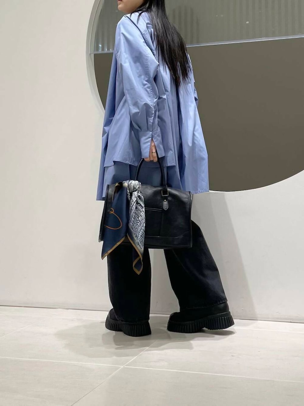 ブラック系のデニムパンツ、ブルー系のワンピース、ブラック系のスニーカーを着用したレディースの冬コーディネートの2枚目の写真