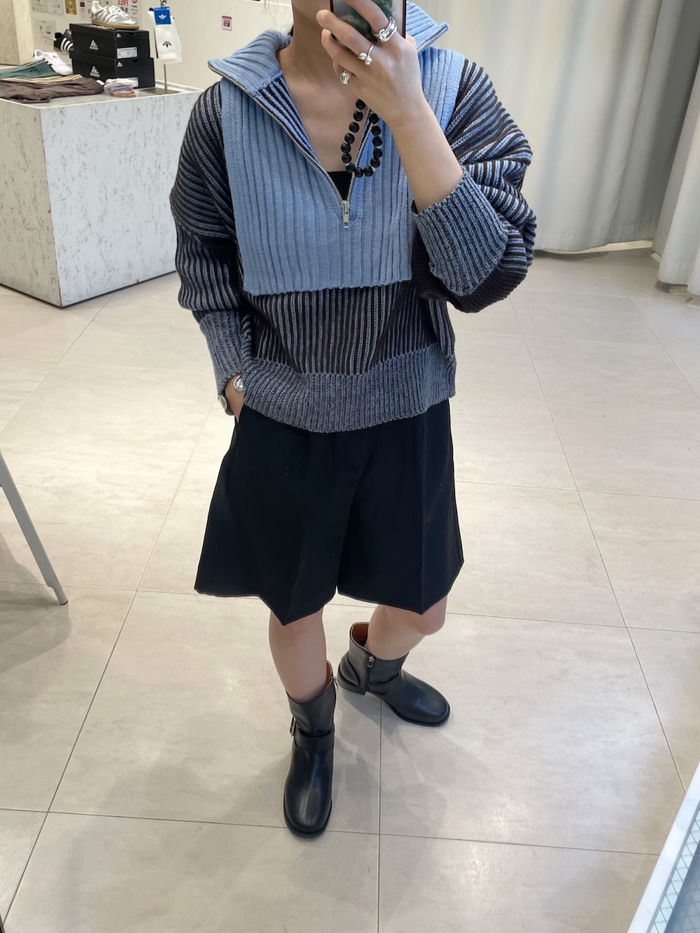 ブルー系のニット/セーター、ブラック系のその他パンツ、ブラック系のブーツを着用したレディースの秋コーディネートの3枚目の写真