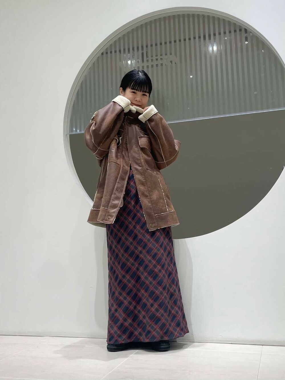 ホワイト系のニット/セーター、ブラウン系のその他アウター、グレー系のその他シューズを着用したレディースの冬コーディネートの3枚目の写真