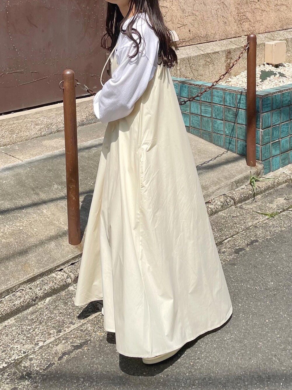 レッド系のスニーカー、ホワイト系のワンピース、ホワイト系のTシャツ/カットソーを着用したレディースの春コーディネートの2枚目の写真