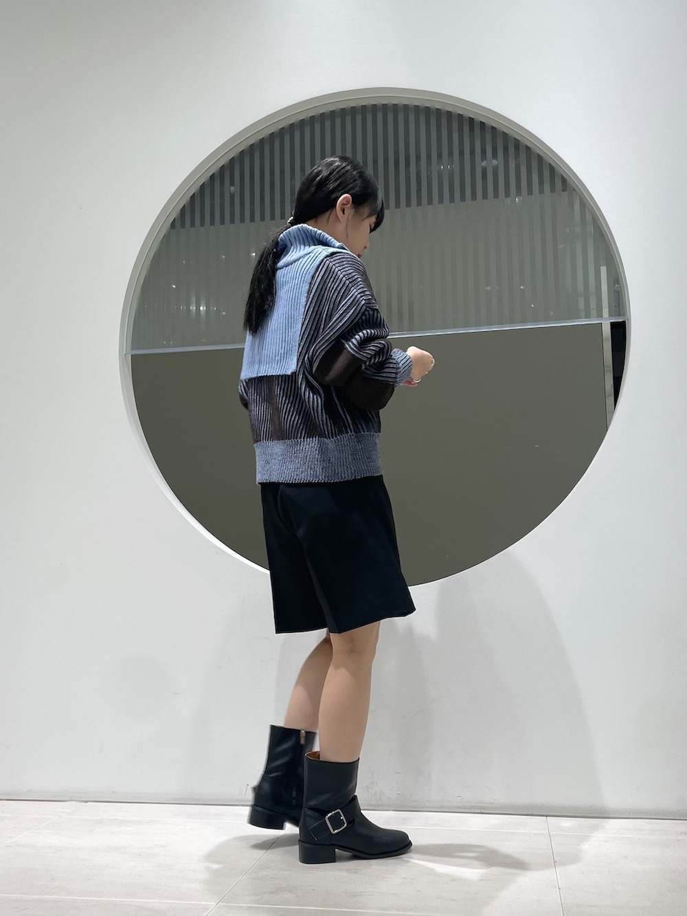 ブルー系のニット/セーター、ブラック系のその他パンツ、ブラック系のブーツを着用したレディースの秋コーディネートの2枚目の写真