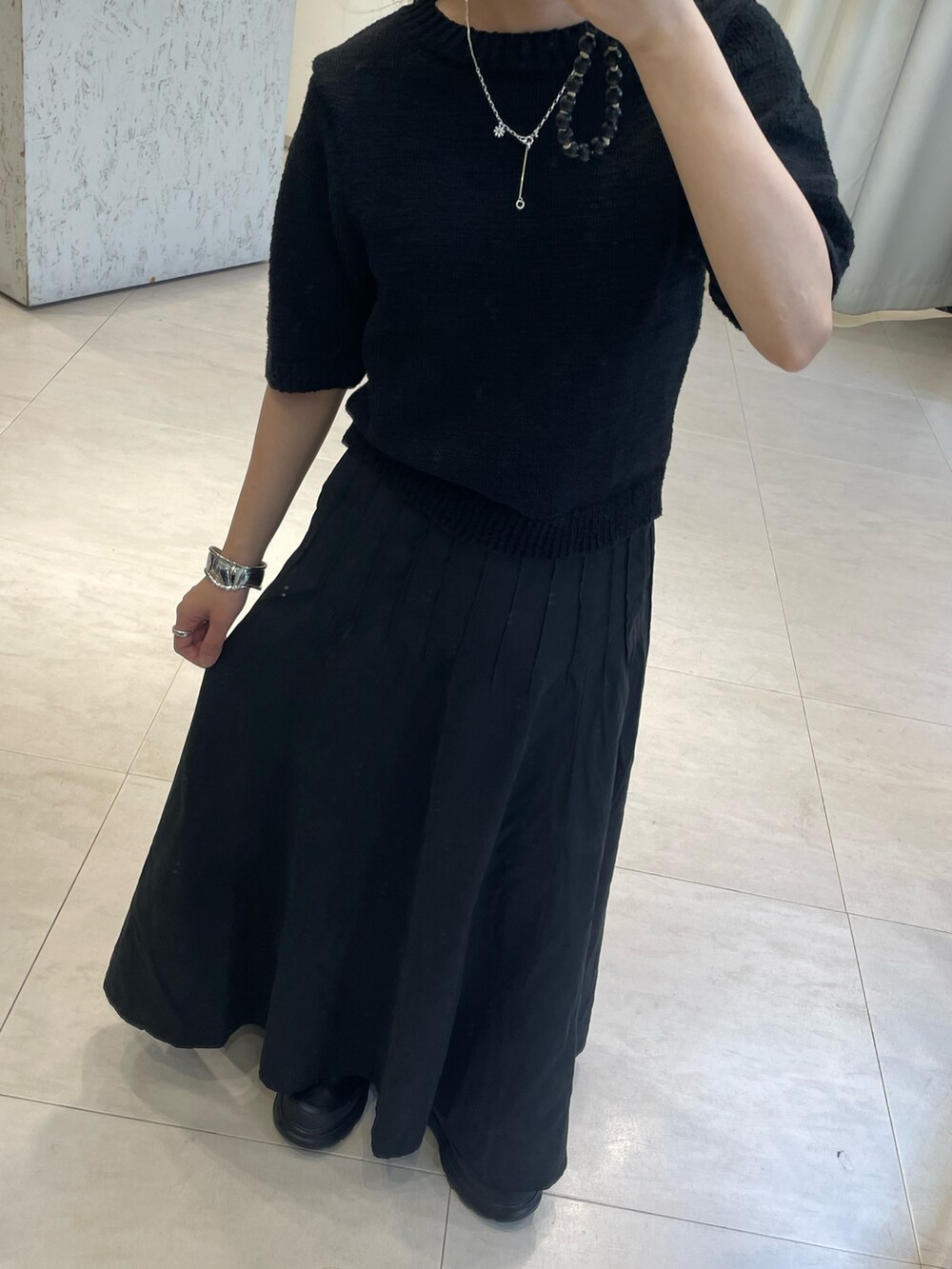 ブラック系のスカート、ブラック系のブーツ、ブラック系のニット/セーターを着用したレディースの秋コーディネートの3枚目の写真