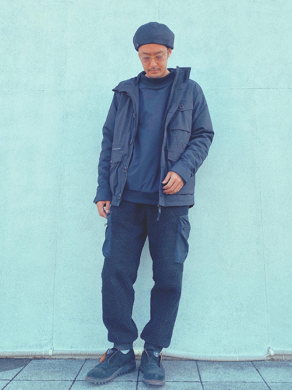 ブラック系のダウンベスト、ブラック系のカーゴパンツ、ブラック系のミリタリージャケットを着用したメンズの冬コーディネートの4枚目の写真