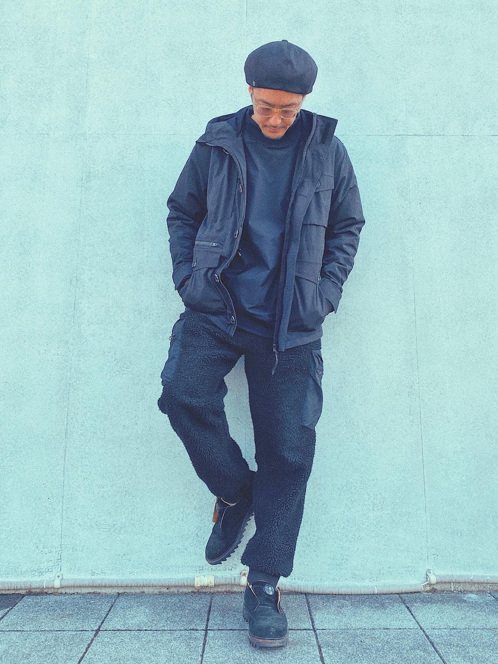 ブラック系のダウンベスト、ブラック系のカーゴパンツ、ブラック系のミリタリージャケットを着用したメンズの冬コーディネートの2枚目の写真