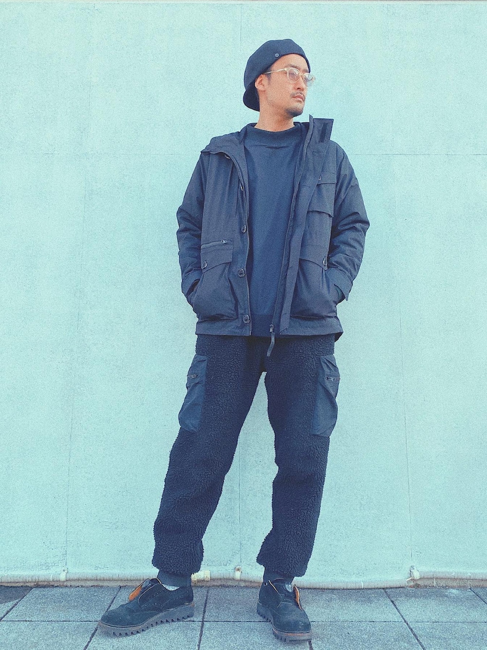 ブラック系のダウンベスト、ブラック系のカーゴパンツ、ブラック系のミリタリージャケットを着用したメンズの冬コーディネートの3枚目の写真