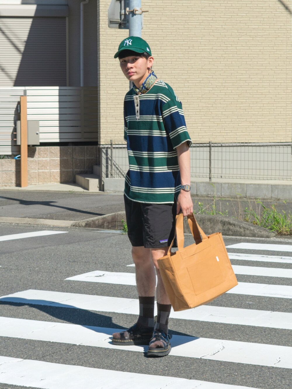 グリーン系のTシャツ/カットソー、ブラック系のその他パンツ、ベージュ系のトートバッグを着用したメンズの夏コーディネートの2枚目の写真