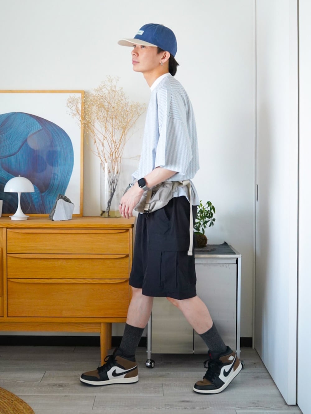 ホワイト系のTシャツ/カットソー、ブラック系のその他パンツ、ベージュ系のクラッチバッグを着用したメンズの夏コーディネートの2枚目の写真