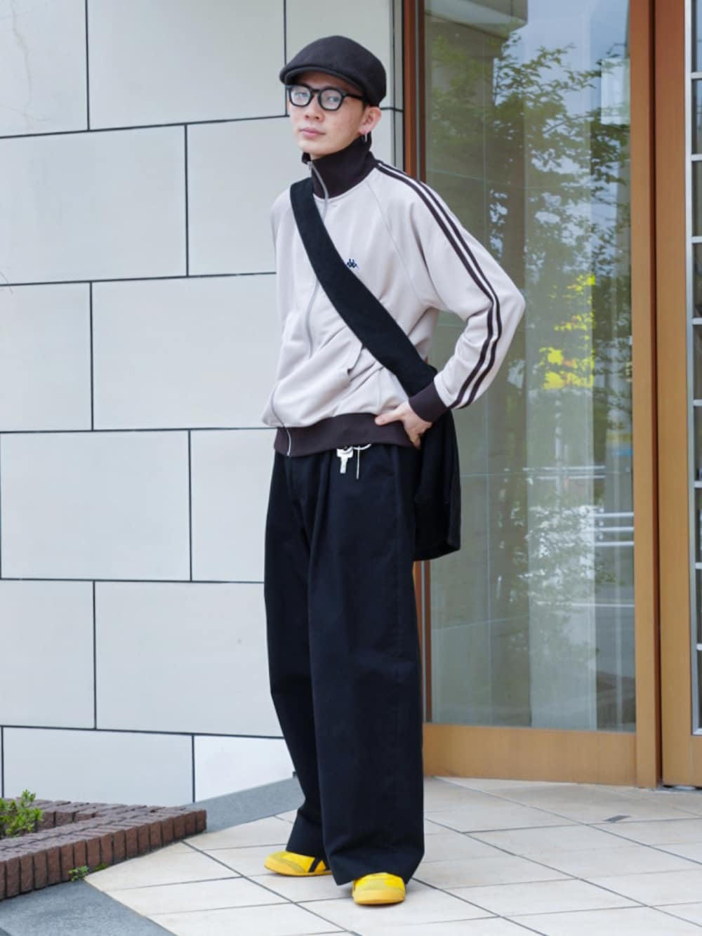 ベージュ系のジャージ、ブラック系のショルダーバッグ、ブラック系のチノパンツを着用したメンズの春コーディネートの3枚目の写真