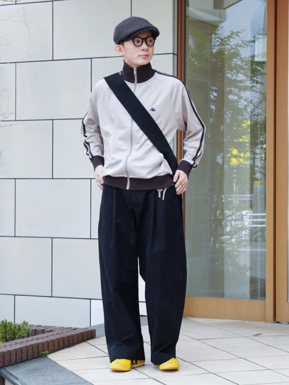 ベージュ系のジャージ、ブラック系のショルダーバッグ、ブラック系のチノパンツを着用したメンズの春コーディネートの2枚目の写真