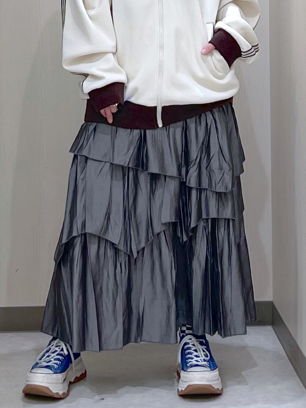ホワイト系のブルゾン、グレー系のスカート、ブルー系のスニーカーを着用したレディースの春コーディネートの3枚目の写真