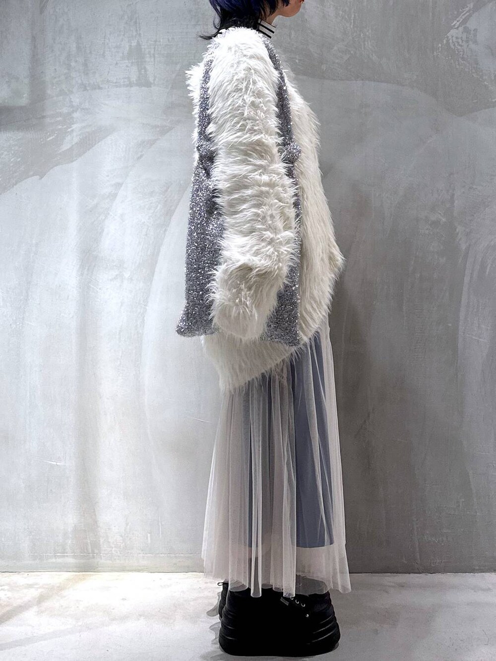 シルバー系のトートバッグ、ホワイト系のカーディガン/ボレロ、ホワイト系のスカートを着用したレディースの秋コーディネートの5枚目の写真