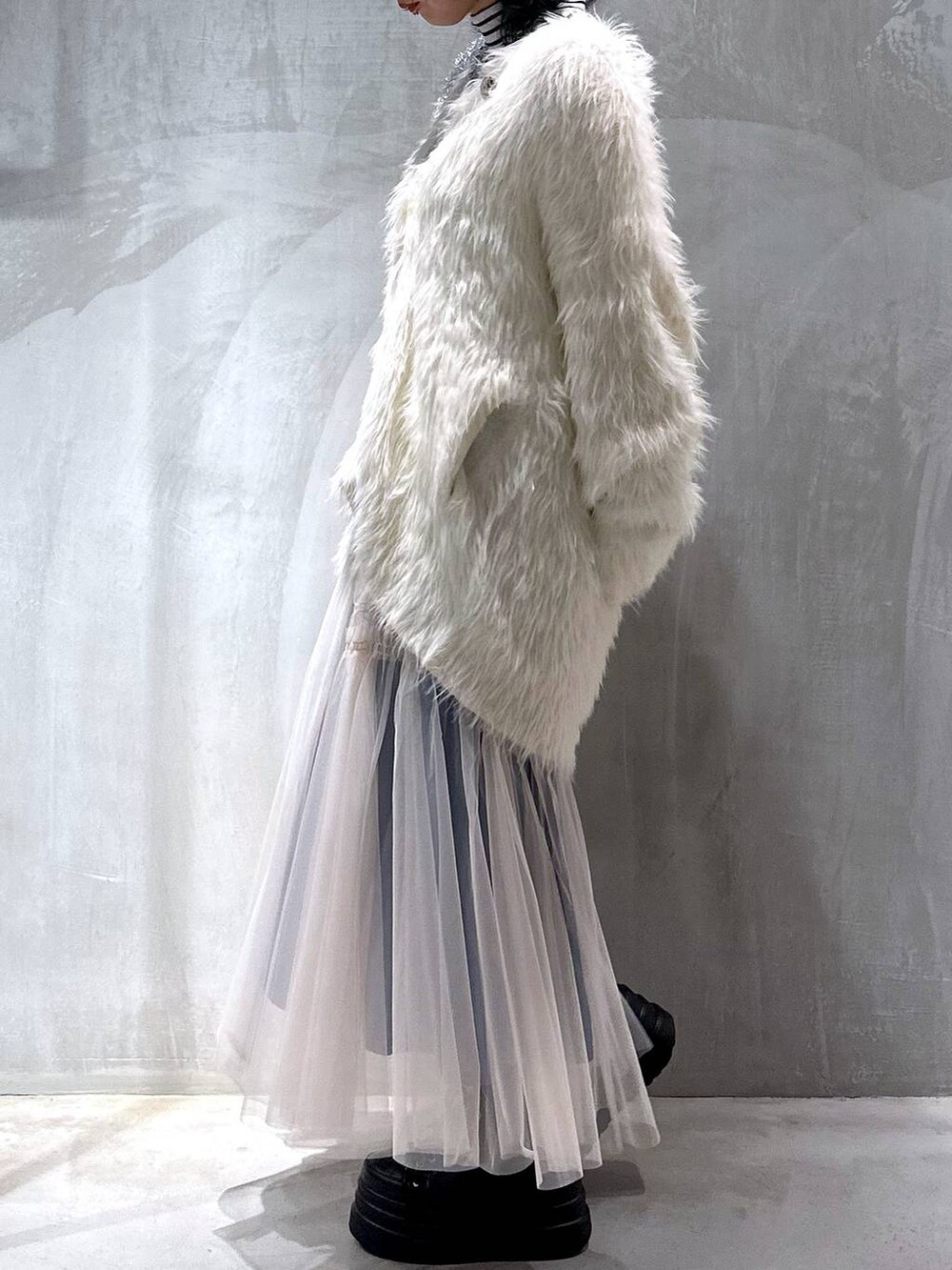 シルバー系のトートバッグ、ホワイト系のカーディガン/ボレロ、ホワイト系のスカートを着用したレディースの秋コーディネートの7枚目の写真