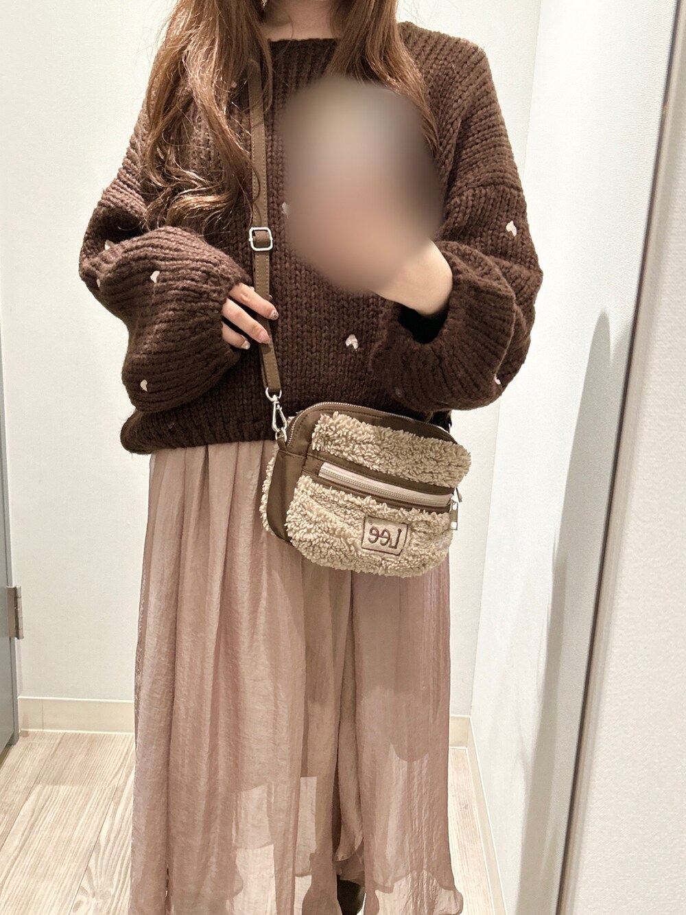 ブラウン系のニット/セーター、ピンク系のスカート、ブラウン系のブーツを着用したレディースの冬コーディネートの3枚目の写真