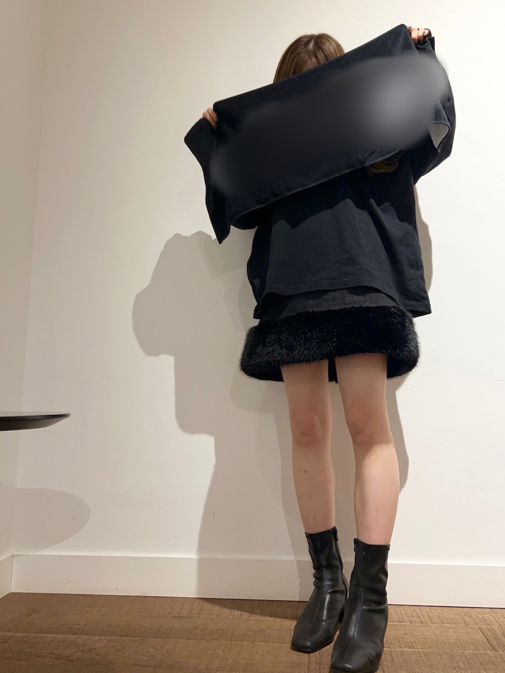 ブラック系のブーツ、ブラック系のスカートを着用したレディースの冬コーディネートの2枚目の写真