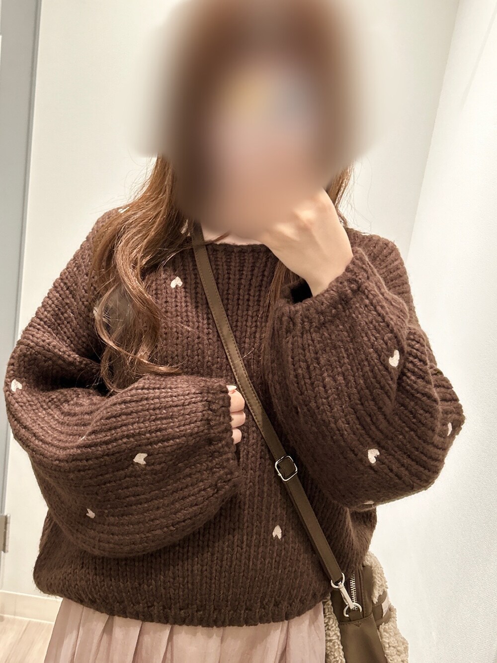 ブラウン系のニット/セーター、ピンク系のスカート、ブラウン系のブーツを着用したレディースの冬コーディネートの4枚目の写真