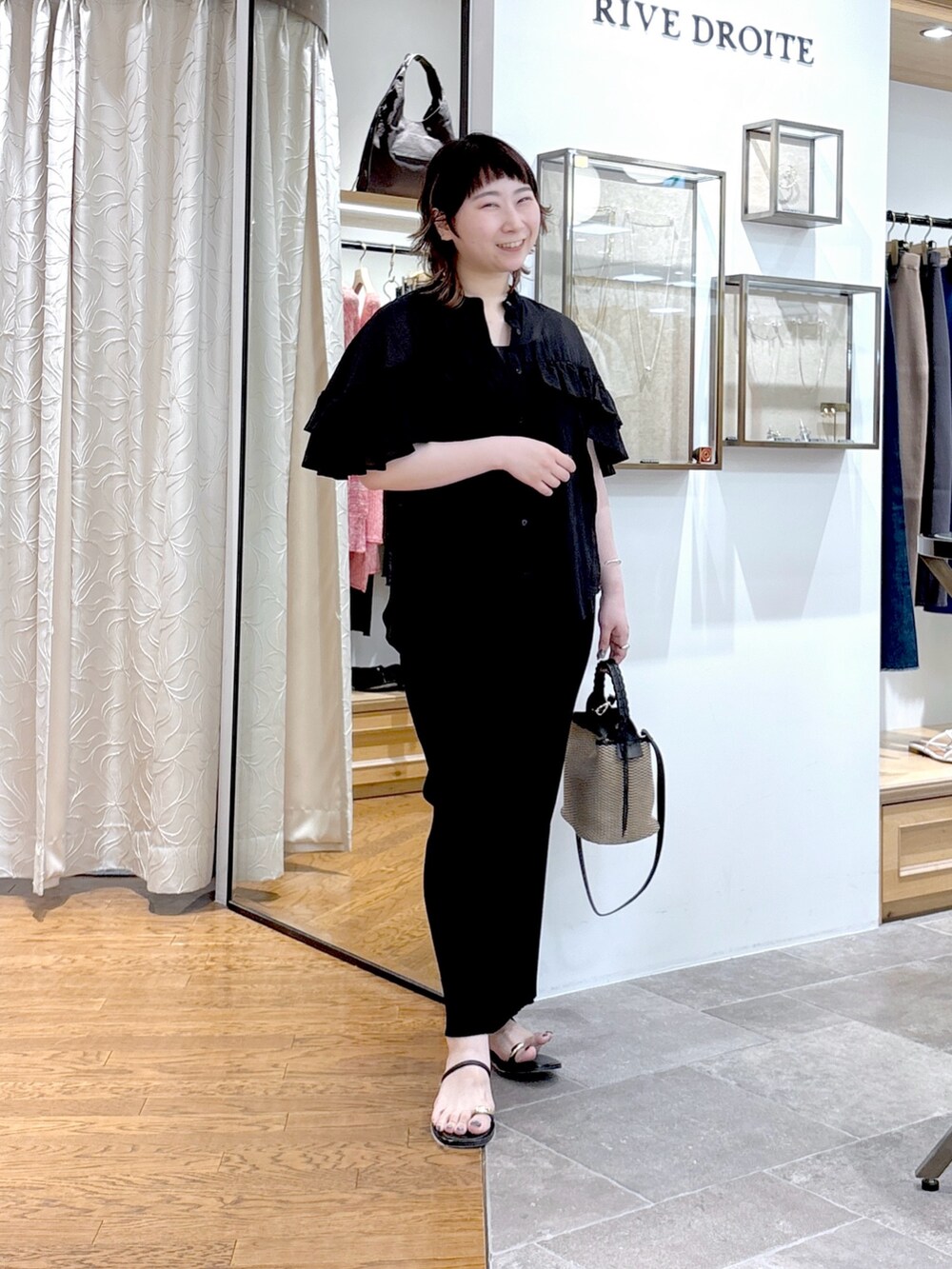 グレー系のタンクトップ、ブラック系のシャツ/ブラウス、ブラック系のハンドバッグを着用したレディースの夏コーディネートの2枚目の写真