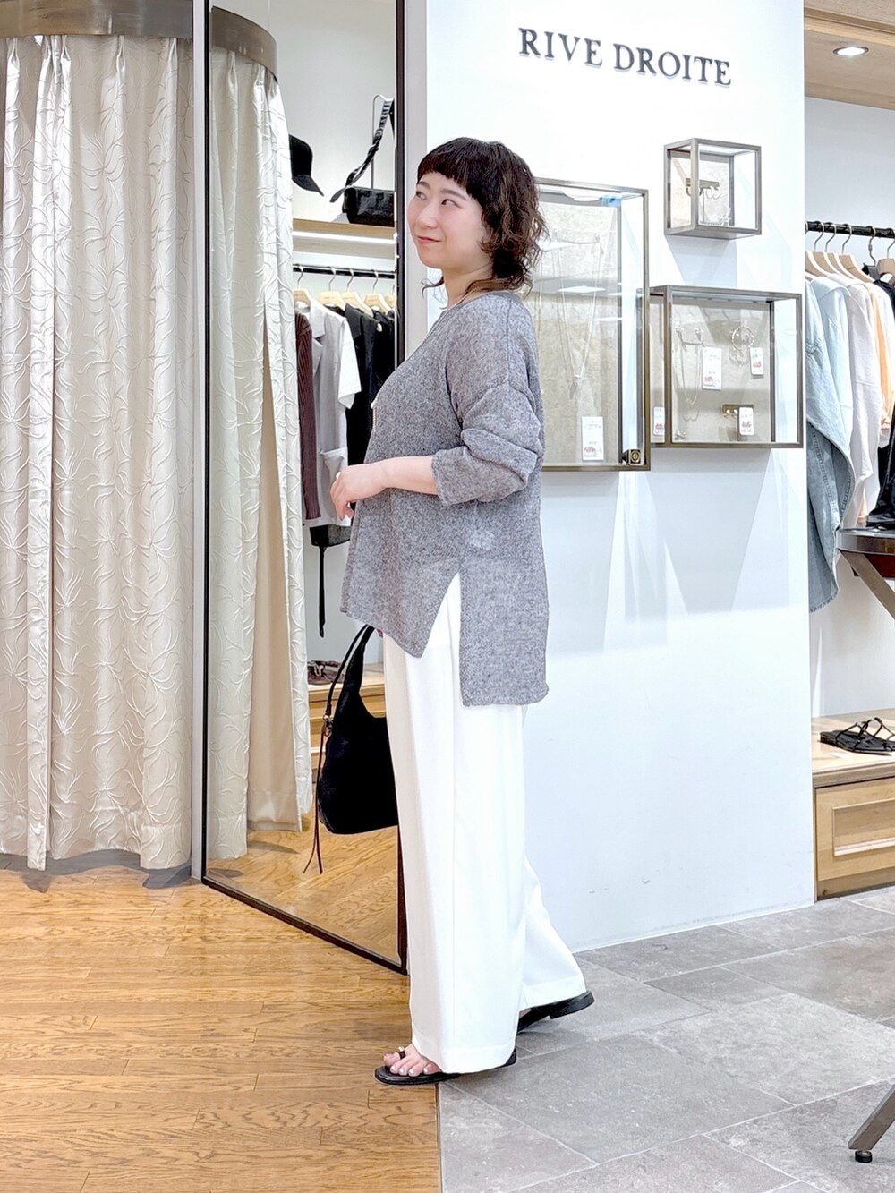 グレー系のニット/セーター、グレー系のタンクトップ、ブラック系のハンドバッグを着用したレディースの夏コーディネートの2枚目の写真