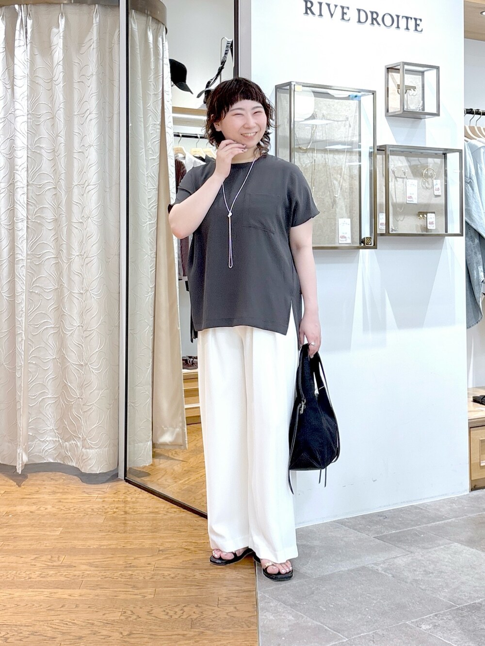 グレー系のシャツ/ブラウス、ブラック系のテーラードジャケット、ブラック系のハンドバッグを着用したレディースの夏コーディネートの5枚目の写真