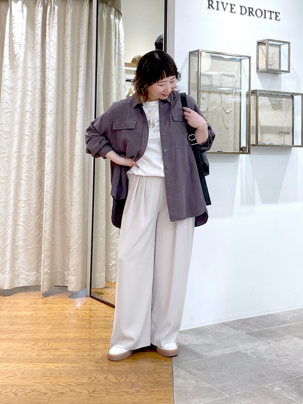 グレー系のスラックス、グレー系のシャツ/ブラウス、ホワイト系のTシャツ/カットソーを着用したレディースの春コーディネートの4枚目の写真