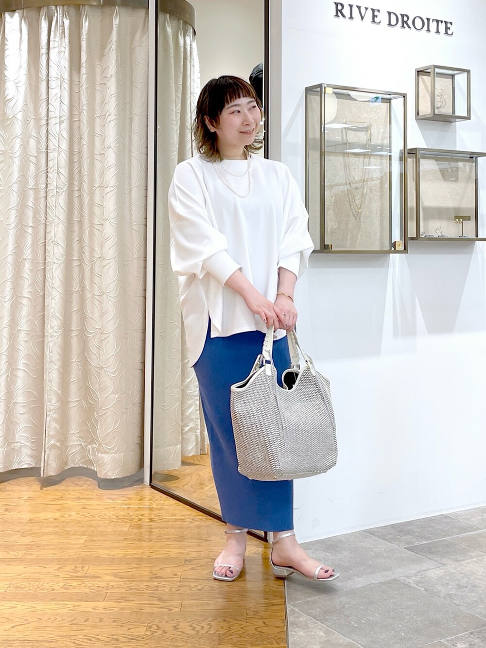 ホワイト系のTシャツ/カットソー、ブルー系のスカート、ホワイト系のトートバッグを着用したレディースの春コーディネートの4枚目の写真