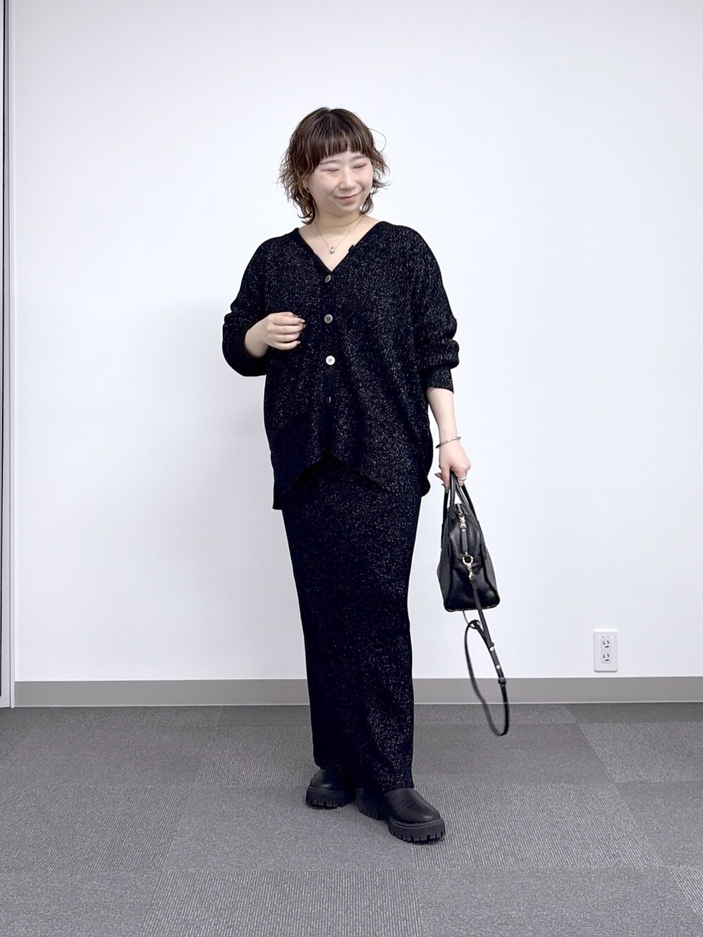 ブラック系のその他アウター、ブラック系のスカート、ブラック系のニット/セーターを着用したレディースの秋コーディネートの3枚目の写真