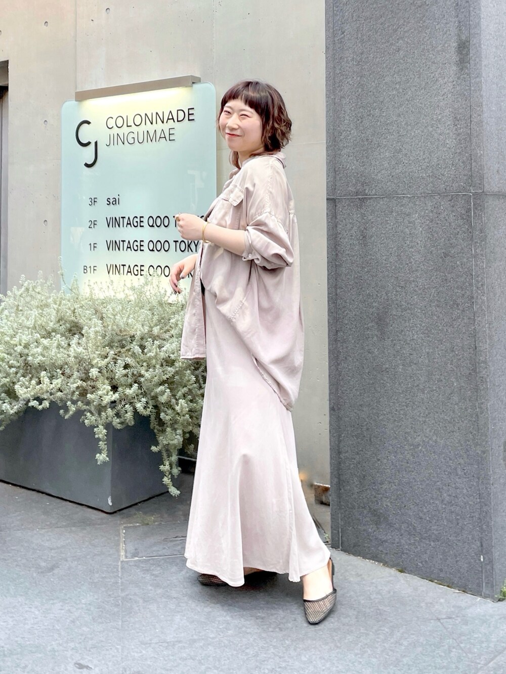 グレー系のシャツ/ブラウス、グレー系のスカート、ブラック系のパンプスを着用したレディースの春コーディネートの2枚目の写真