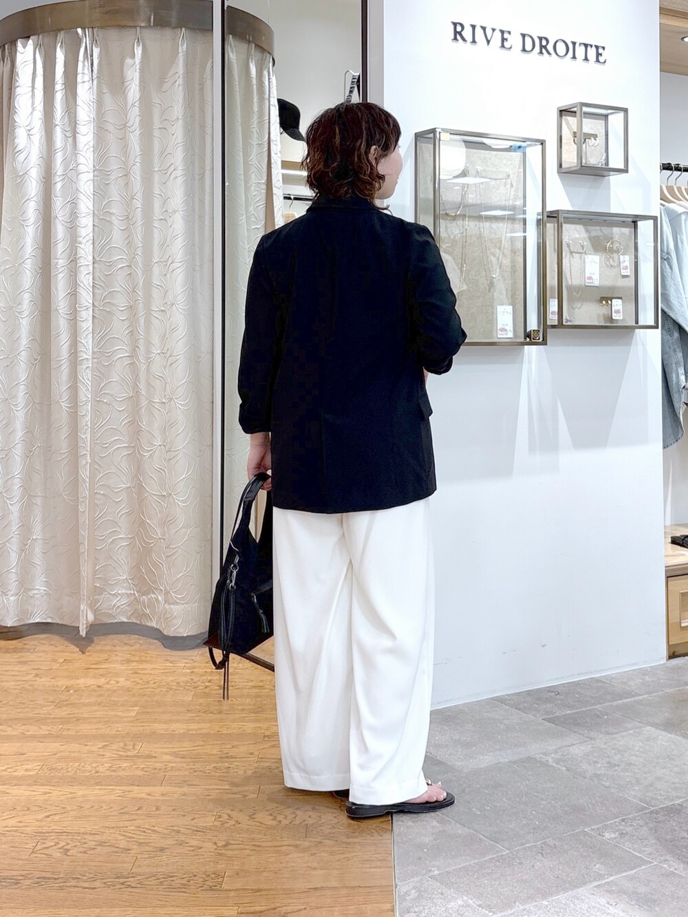 グレー系のシャツ/ブラウス、ブラック系のテーラードジャケット、ブラック系のハンドバッグを着用したレディースの夏コーディネートの3枚目の写真