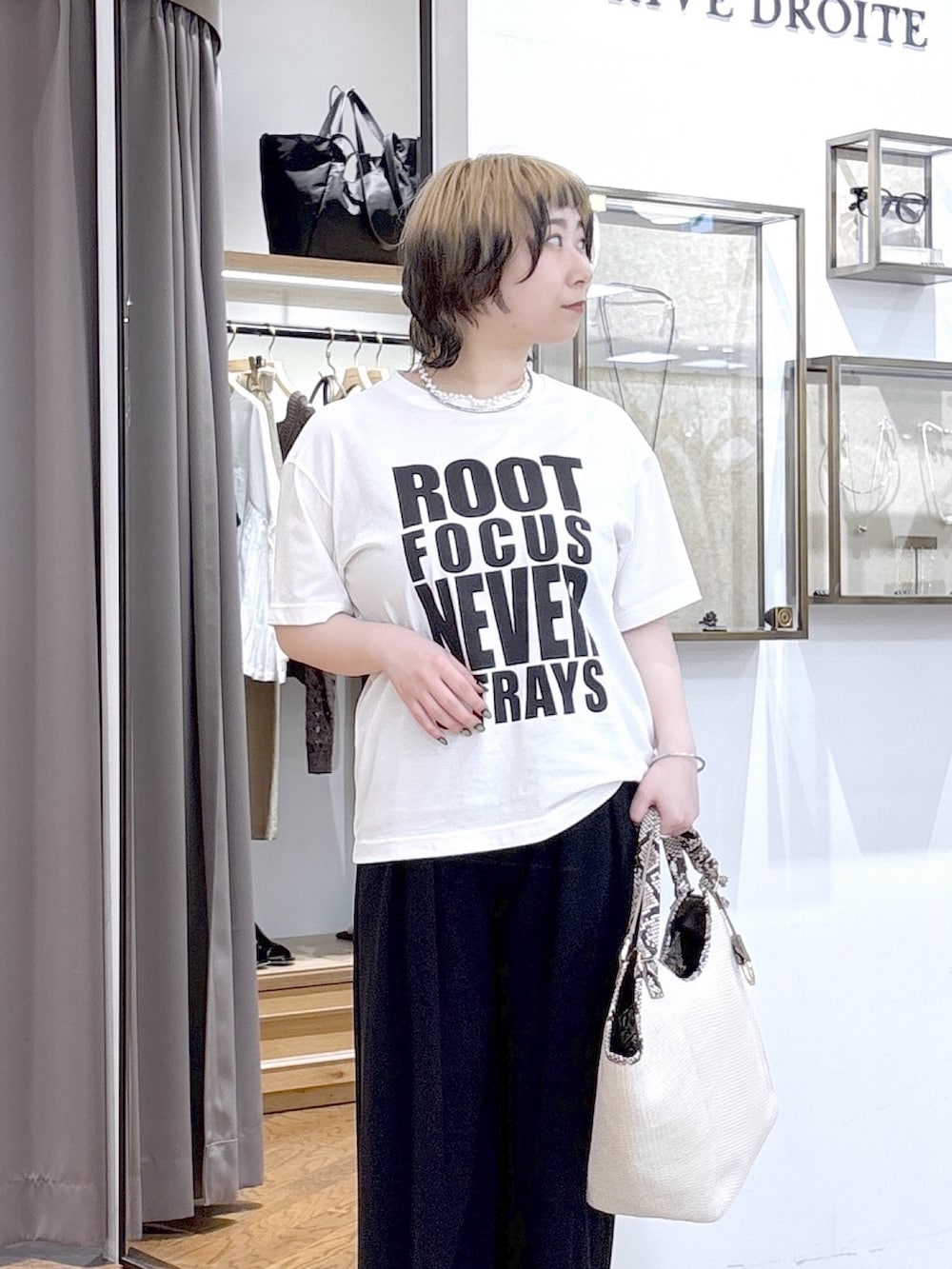 ホワイト系のTシャツ/カットソー、ブラック系のテーラードジャケット、ベージュ系のハンドバッグを着用したレディースの夏コーディネートの5枚目の写真