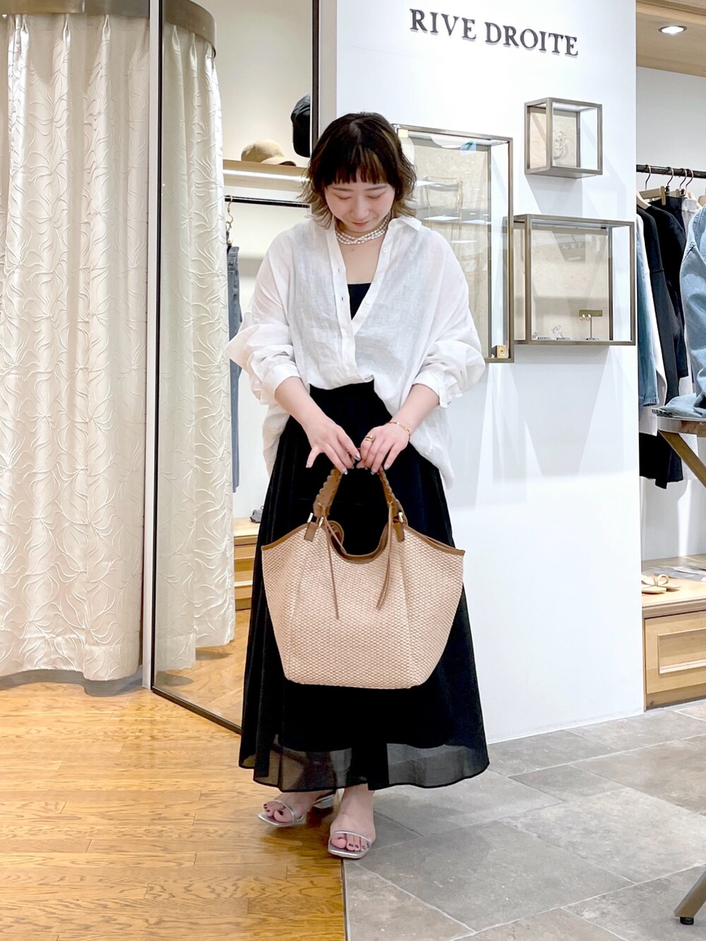 ブラック系のタンクトップ、ホワイト系のシャツ/ブラウス、ブラック系のスカートを着用したレディースの春コーディネートの4枚目の写真