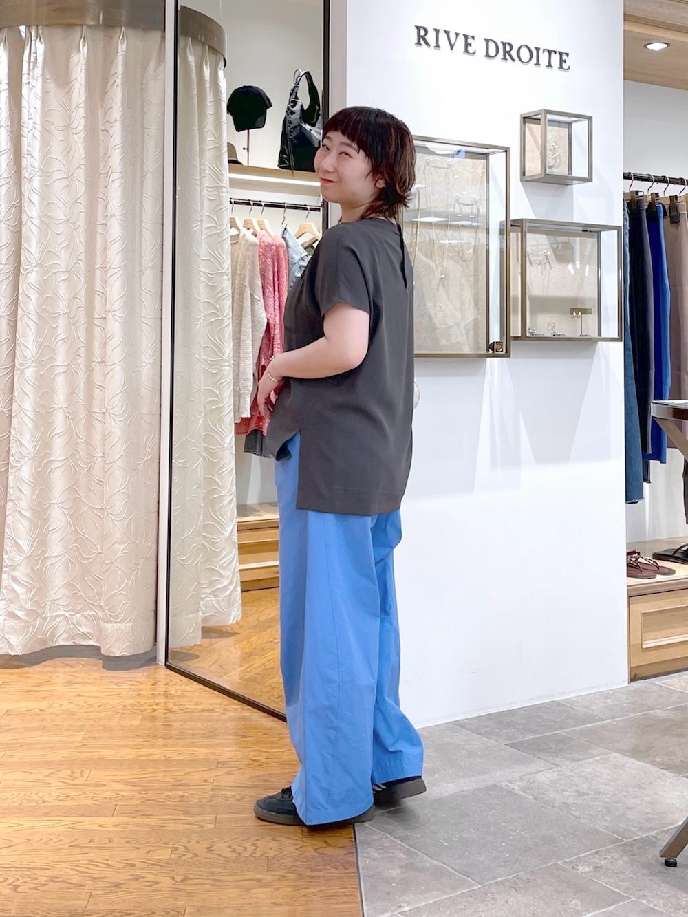 ホワイト系のハンドバッグ、グレー系のシャツ/ブラウス、ブルー系のその他パンツを着用したレディースの夏コーディネートの2枚目の写真