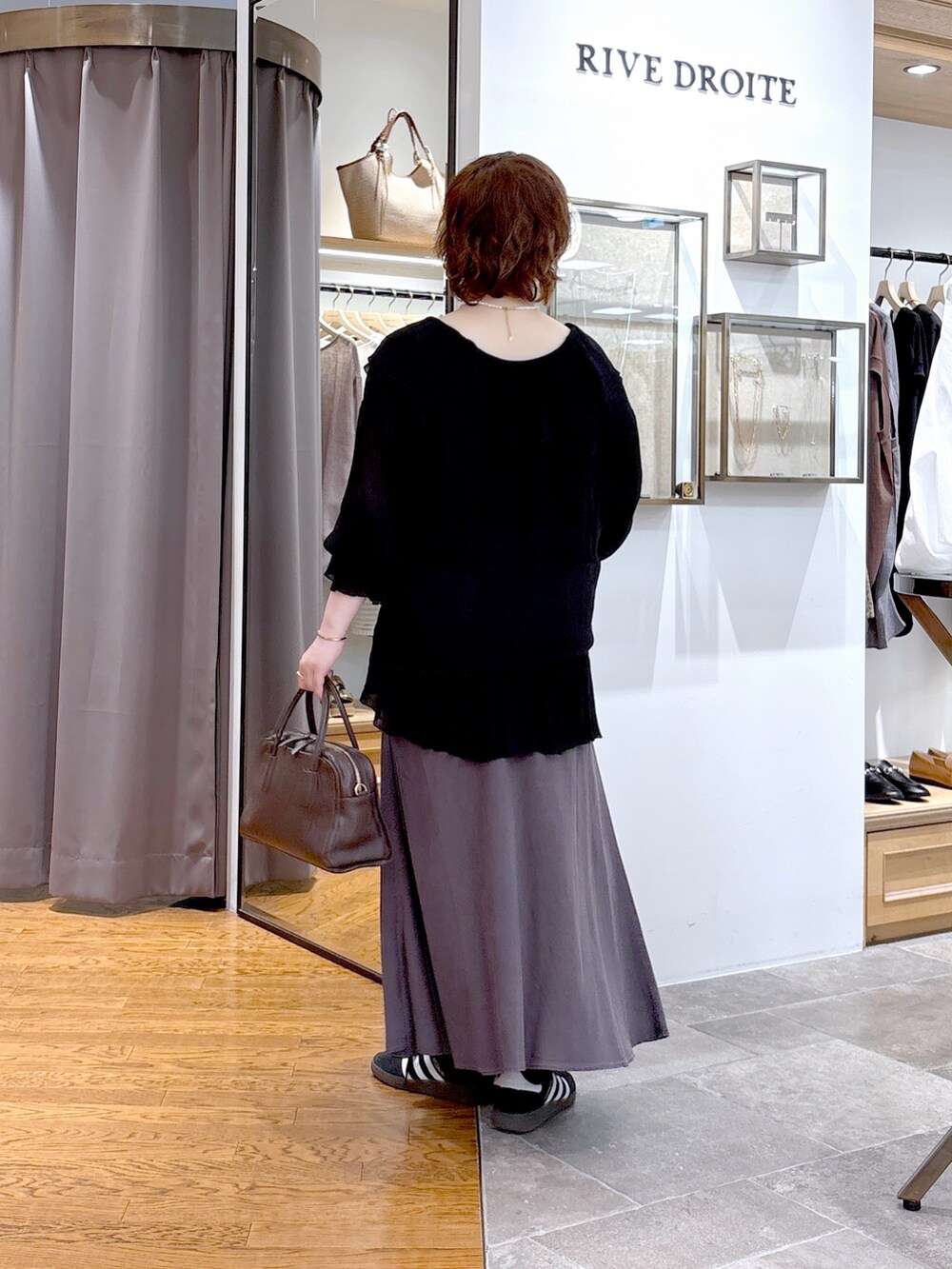 ブラック系のシャツ/ブラウス、ブラウン系のボストンバッグ、グレー系のスカートを着用したレディースの秋コーディネートの3枚目の写真