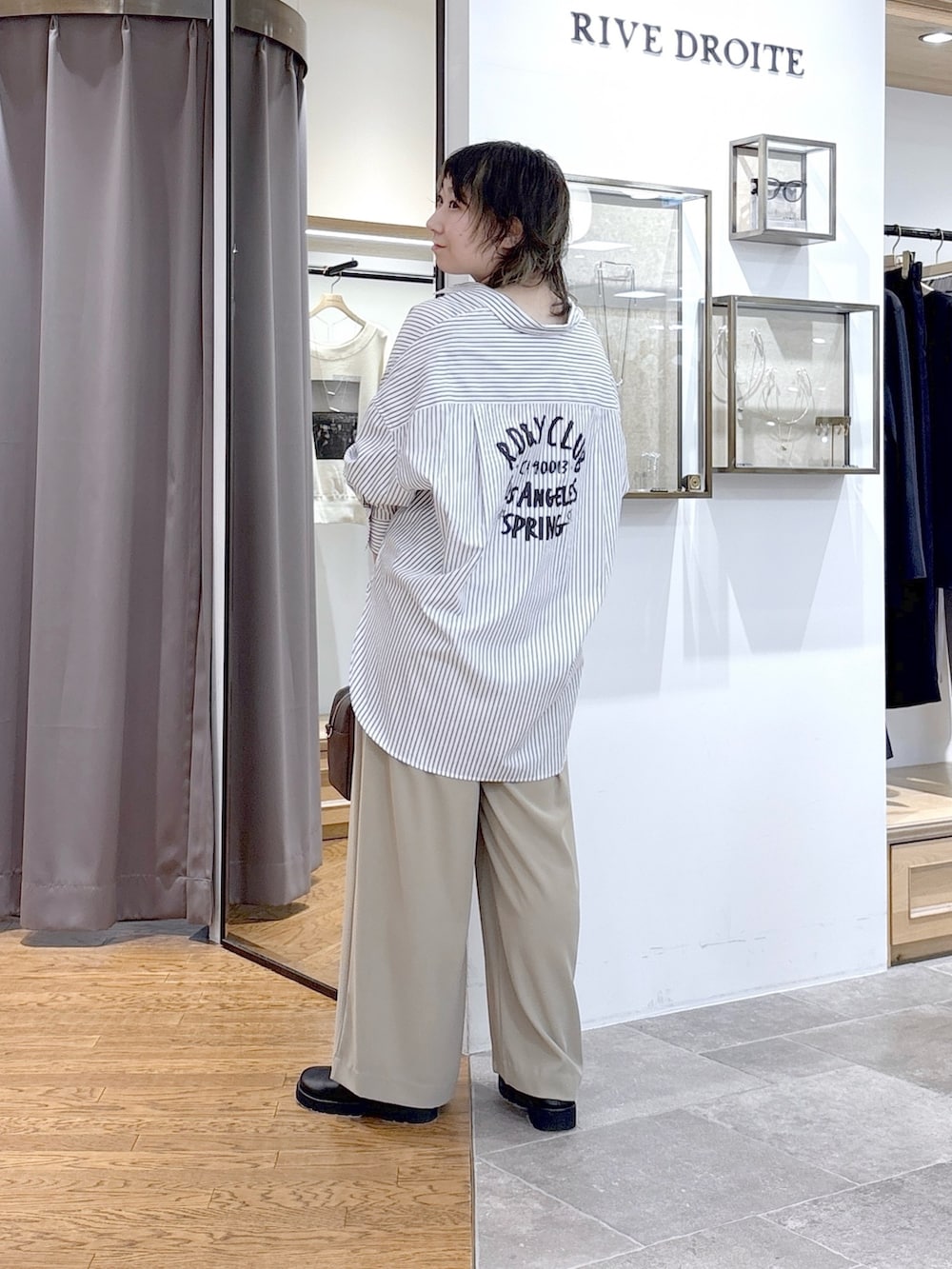 ブラウン系のボストンバッグ、イエロー系のスラックス、ホワイト系のシャツ/ブラウスを着用したレディースの春コーディネートの3枚目の写真