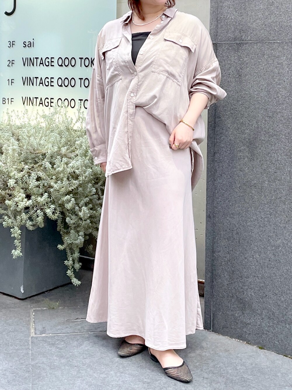 グレー系のシャツ/ブラウス、グレー系のスカート、ブラック系のパンプスを着用したレディースの春コーディネートの4枚目の写真