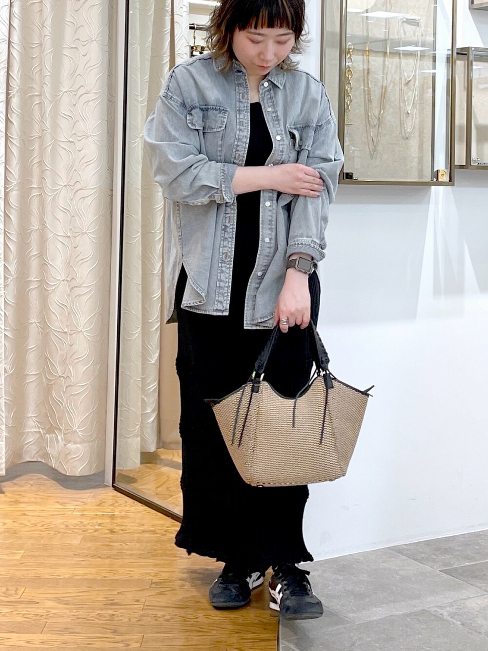 ブルー系のシャツ/ブラウス、ブラック系のニット/セーター、ブラック系のスカートを着用したレディースの春コーディネートの5枚目の写真