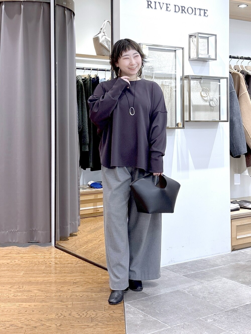 グレー系のTシャツ/カットソー、グレー系のピーコート、ブラック系のハンドバッグを着用したレディースの秋コーディネートの4枚目の写真