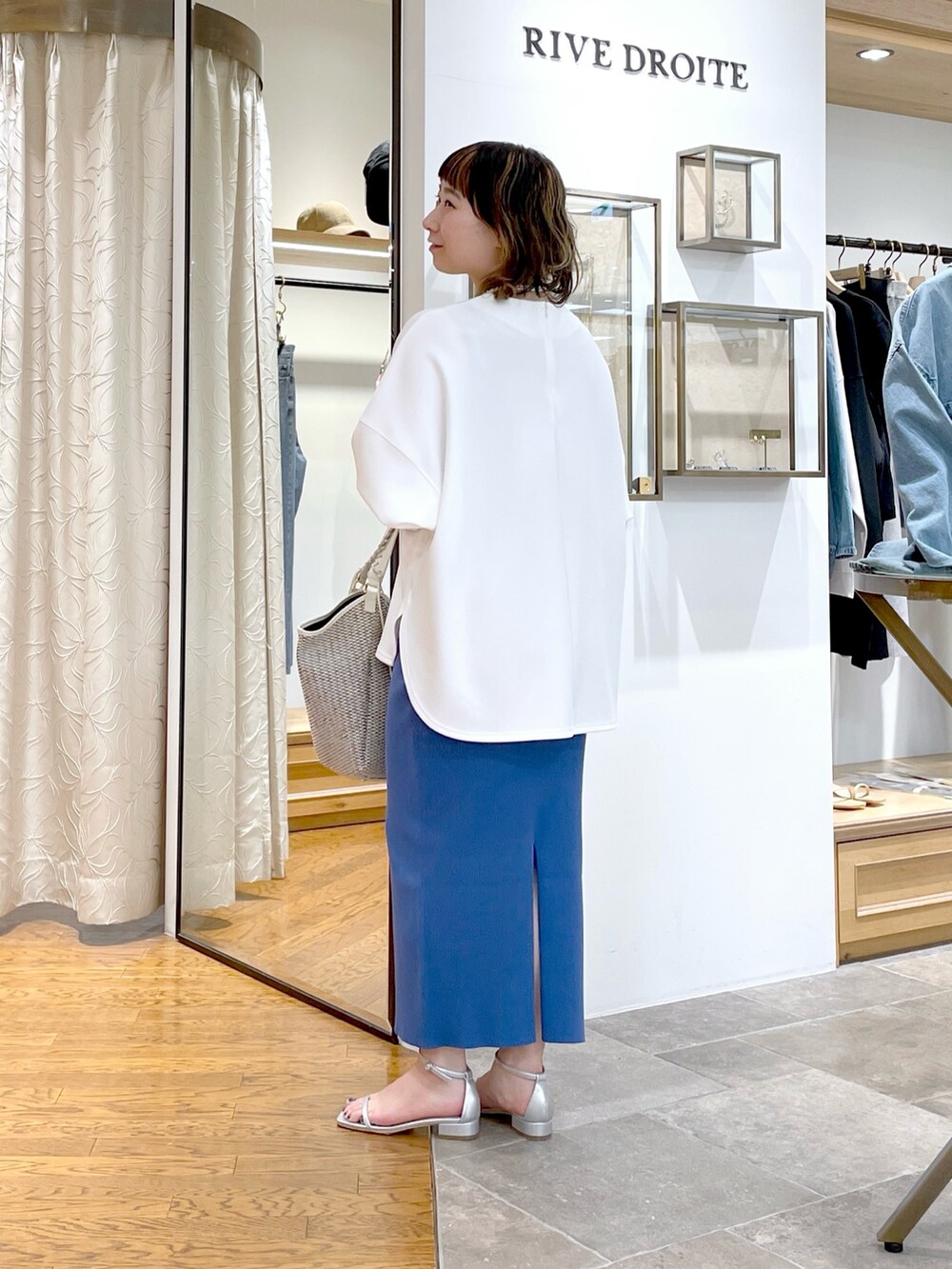 ホワイト系のTシャツ/カットソー、ブルー系のスカート、ホワイト系のトートバッグを着用したレディースの春コーディネートの3枚目の写真