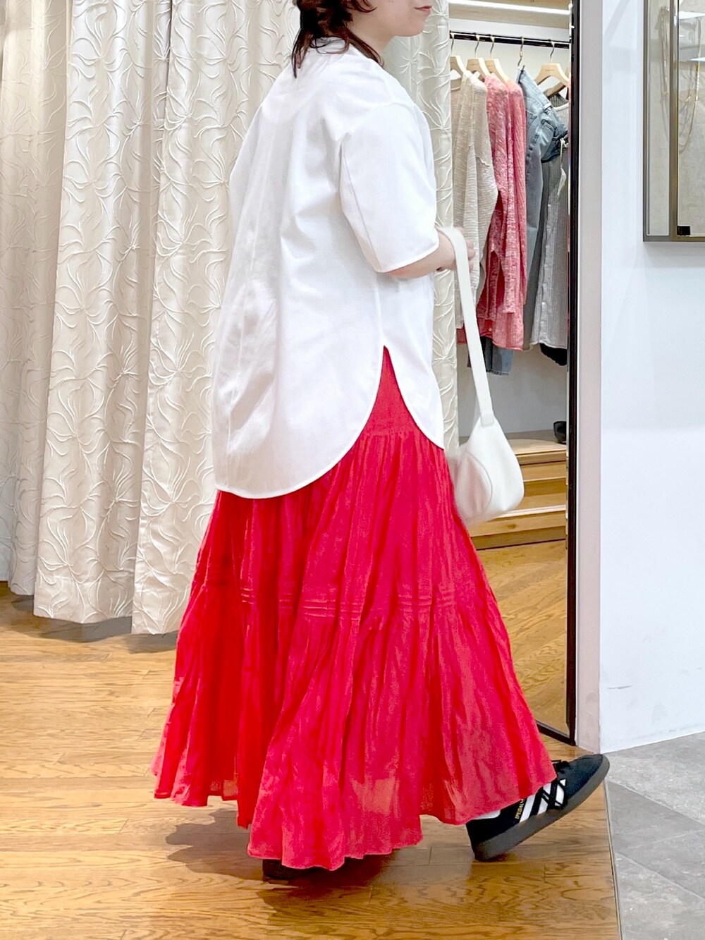 ホワイト系のハンドバッグ、ホワイト系のTシャツ/カットソー、レッド系のスカートを着用したレディースの春コーディネートの3枚目の写真