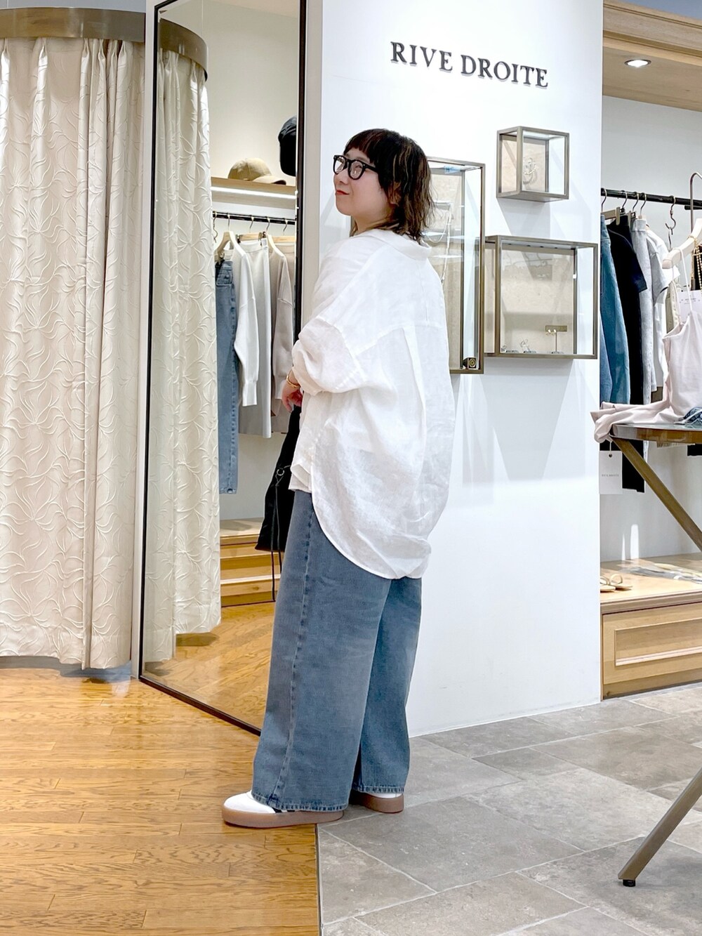 ホワイト系のTシャツ/カットソー、ホワイト系のシャツ/ブラウス、ブラック系のハンドバッグを着用したレディースの春コーディネートの2枚目の写真