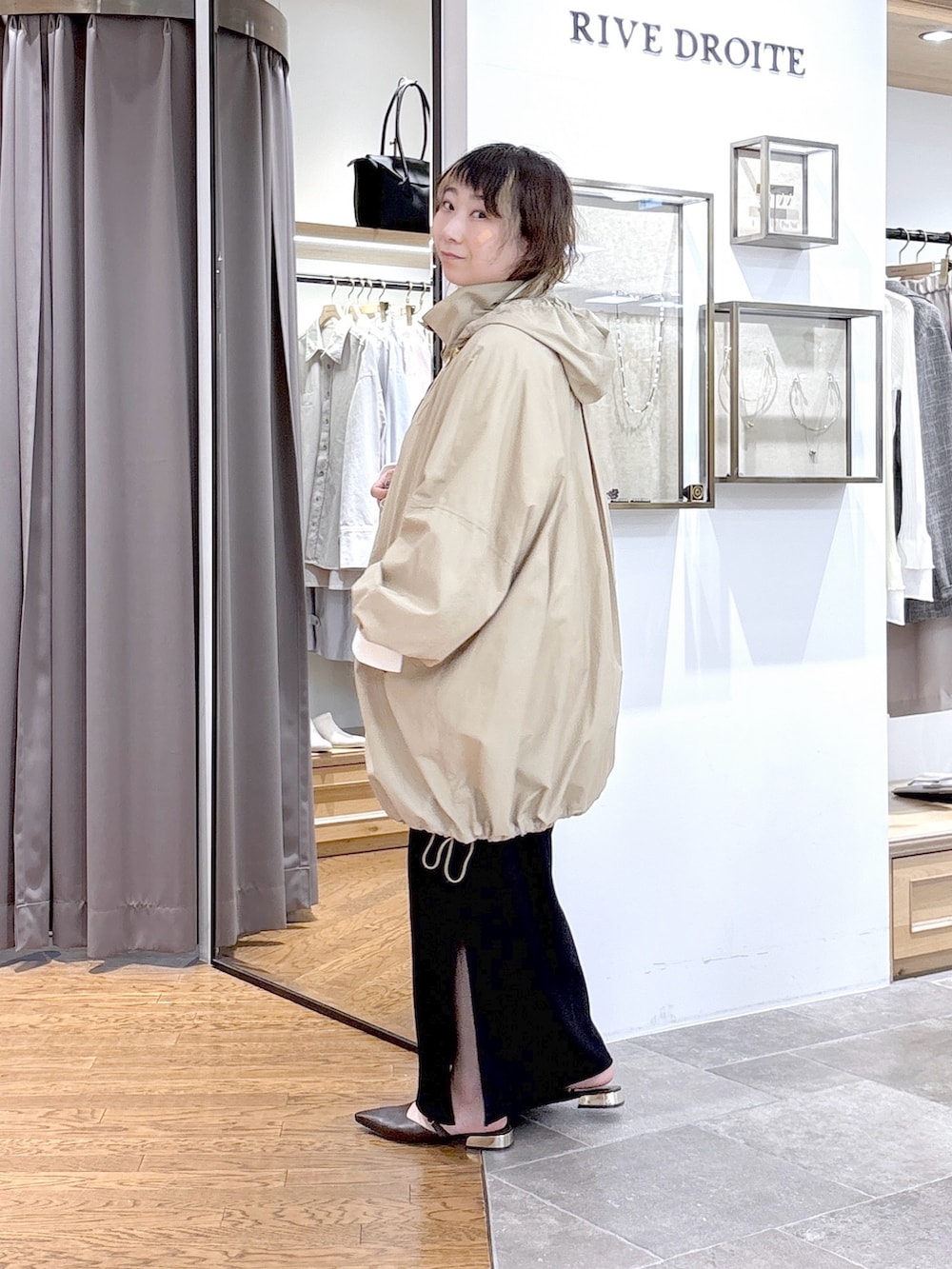 ベージュ系のその他アウター、ブラック系のワンピース、ブラウン系のその他シューズを着用したレディースの春コーディネートの2枚目の写真