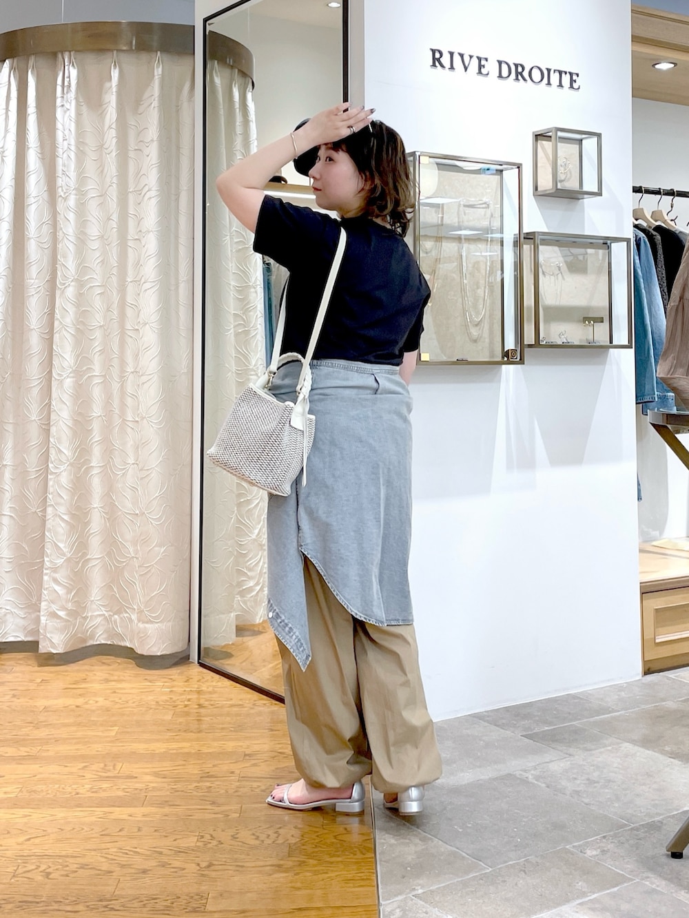 グレー系のTシャツ/カットソー、ホワイト系のハンドバッグ、ブルー系のシャツ/ブラウスを着用したレディースの春コーディネートの2枚目の写真