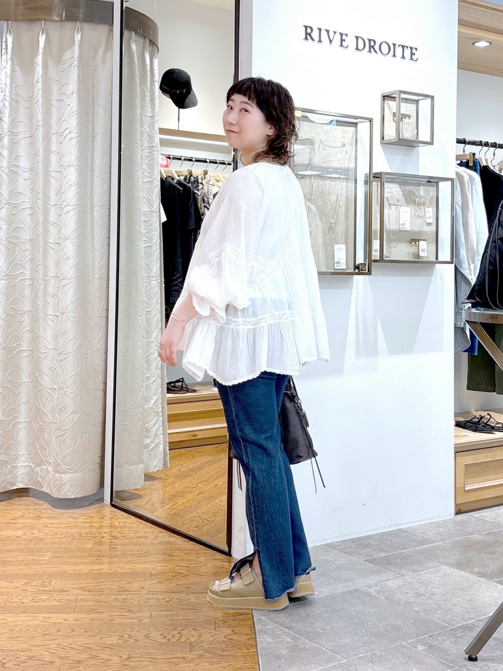 ホワイト系のタンクトップ、ホワイト系のシャツ/ブラウス、グリーン系のハンドバッグを着用したレディースの夏コーディネートの2枚目の写真