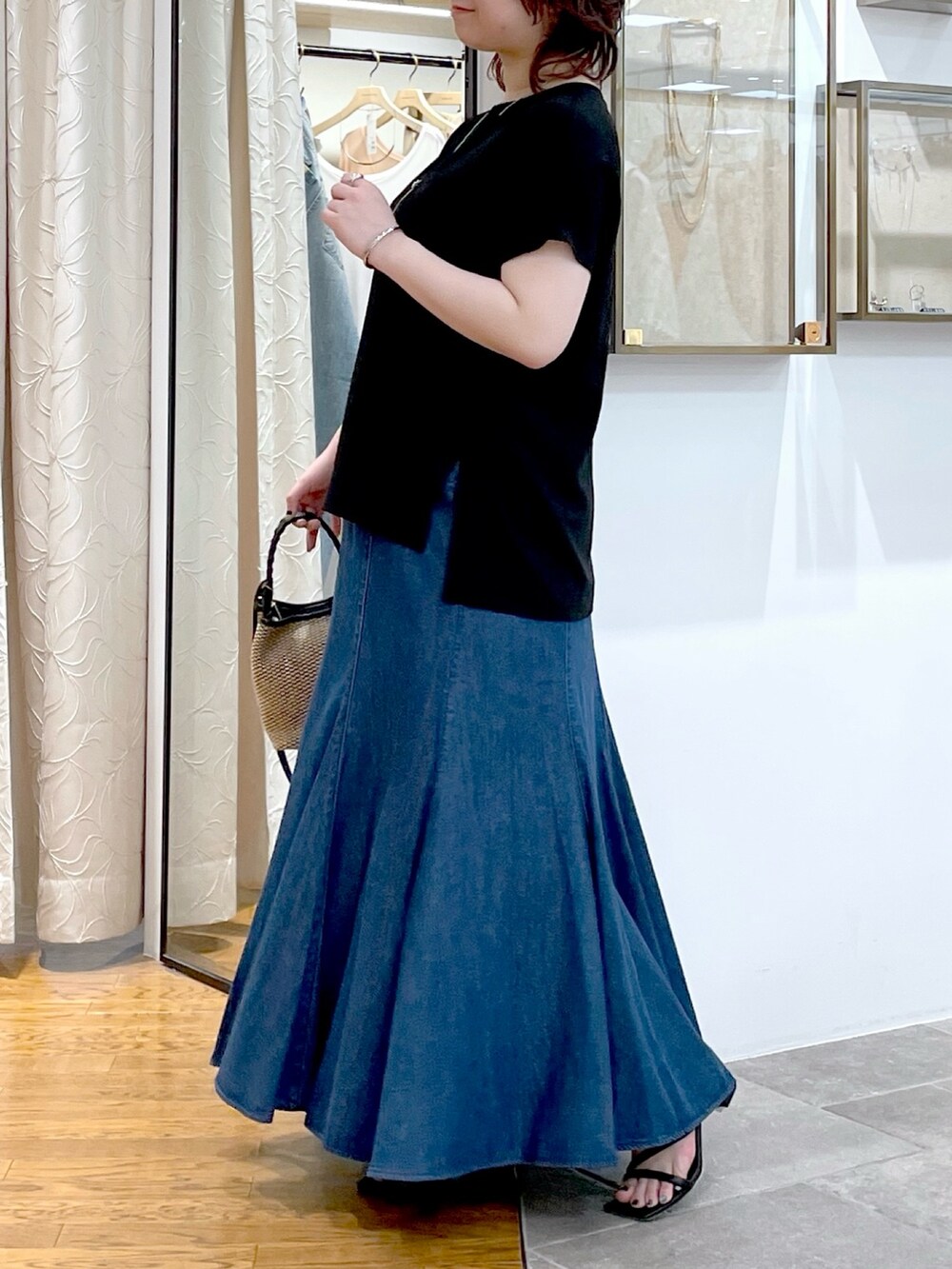 ブラック系のシャツ/ブラウス、ブルー系のスカート、ブラック系のハンドバッグを着用したレディースの春コーディネートの5枚目の写真