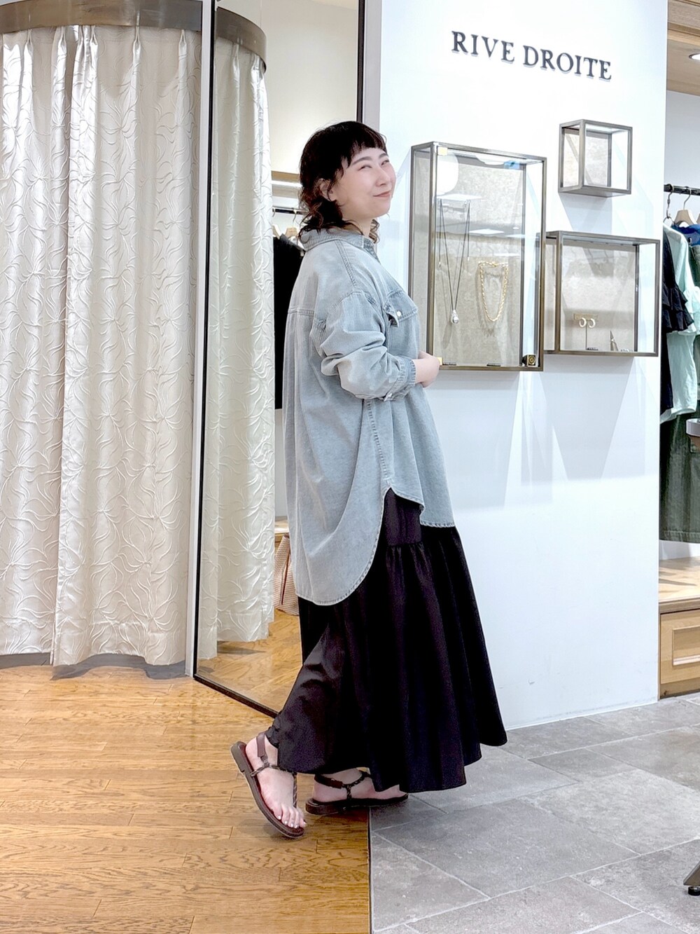 ブラウン系のワンピース、ブラウン系のハンドバッグ、ブルー系のシャツ/ブラウスを着用したレディースの夏コーディネートの2枚目の写真