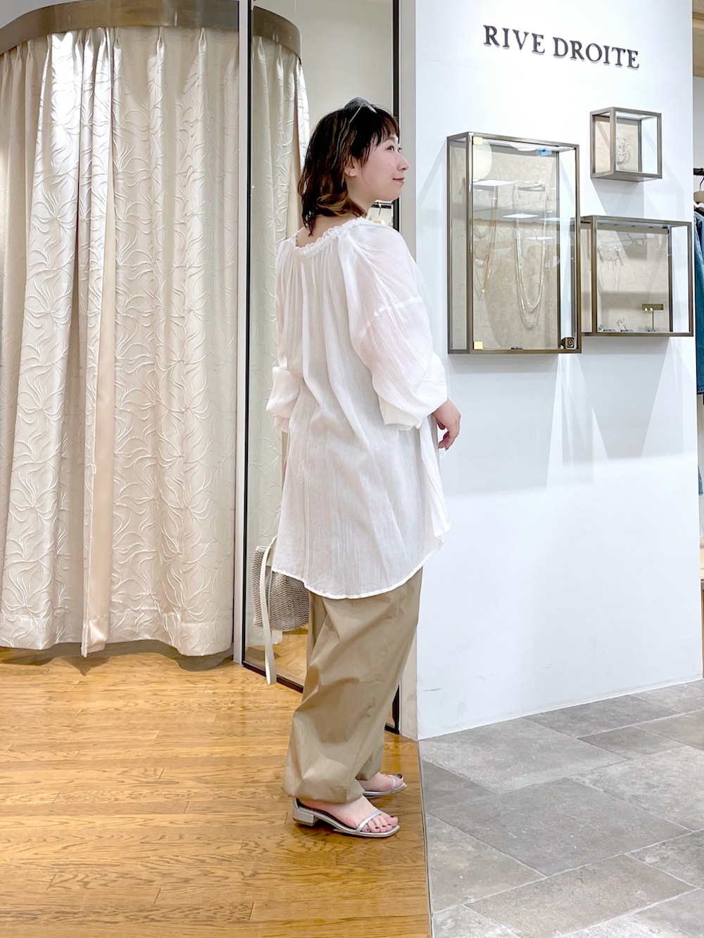 ベージュ系のタンクトップ、ホワイト系のシャツ/ブラウス、ホワイト系のハンドバッグを着用したレディースの春コーディネートの3枚目の写真