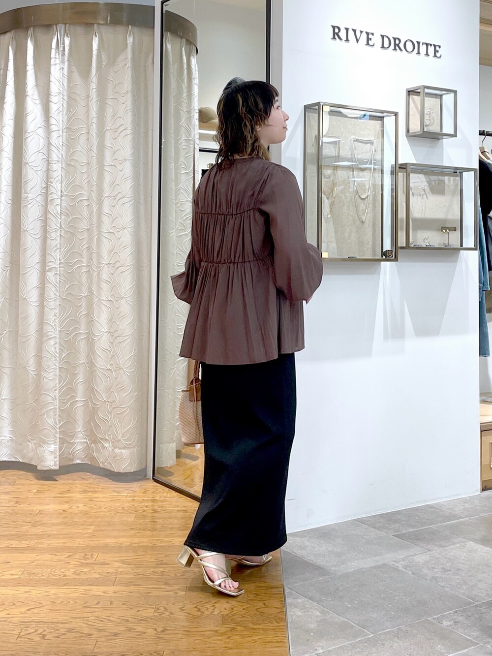 ブラウン系のシャツ/ブラウス、ブラウン系のハンドバッグ、ブラック系のワンピースを着用したレディースの春コーディネートの4枚目の写真