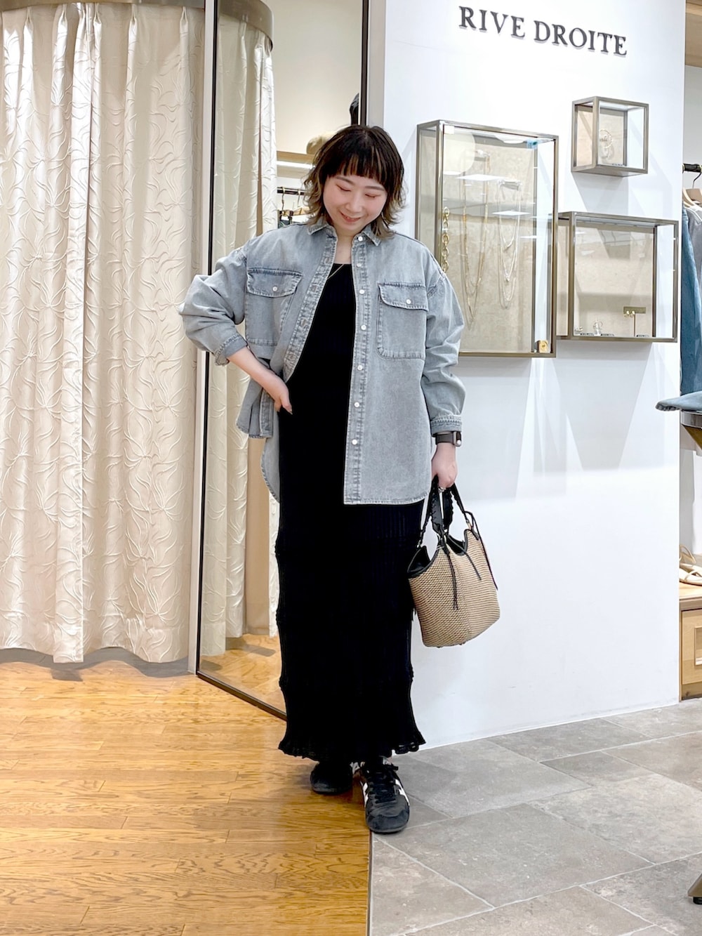 ブルー系のシャツ/ブラウス、ブラック系のニット/セーター、ブラック系のスカートを着用したレディースの春コーディネートの4枚目の写真