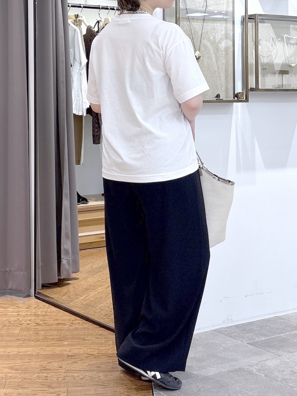 ホワイト系のTシャツ/カットソー、ベージュ系のハンドバッグ、ブラック系のその他パンツを着用したレディースの夏コーディネートの4枚目の写真