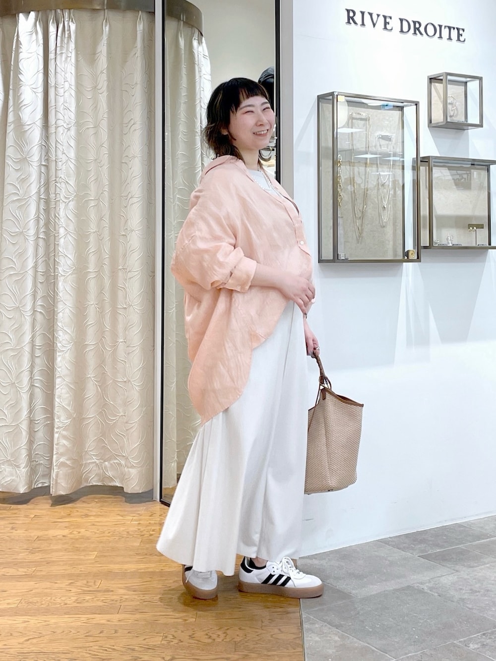 ホワイト系のTシャツ/カットソー、ピンク系のシャツ/ブラウス、ホワイト系のスカートを着用したレディースの春コーディネートの2枚目の写真